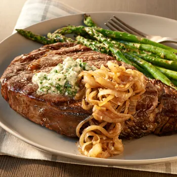 Rib Eye odresci sa sol i paprom, maslacem od plavog sira i karameliziranim lukom