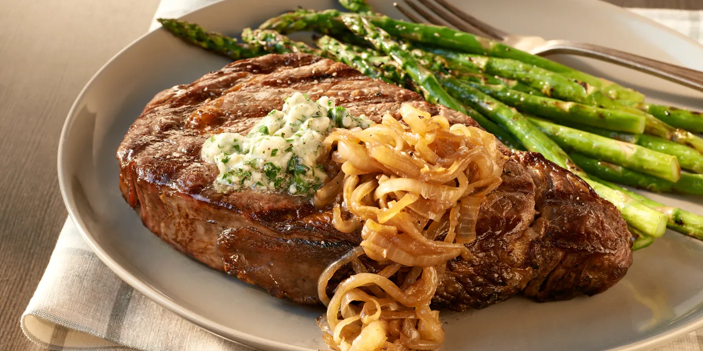 Rib Eye odresci sa sol i paprom, maslacem od plavog sira i karameliziranim lukom